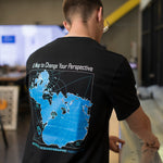 A man viewed from behind wearing a black t-shirt with a large blue and white map graphic on the back, featuring the text 'A Map to Change Your Perspective' and 'WOODS HOLE OCEANOGRAPHIC INSTITUTION'.